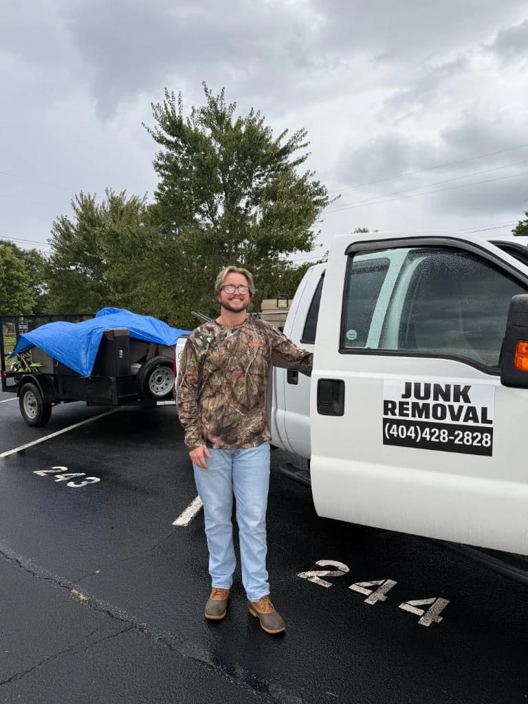 Owner of Famous Hauling & Service standing beside the company truck and trailer